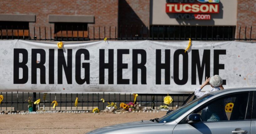 A person takes a photo of a Nancy Guthrie memorial on March 3 in front of the KVOA-TV station in Tucson, Arizona.
