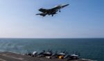 An F/A-18F Super Hornet flies over the flight deck of Nimitz-class aircraft carrier USS Abraham Lincoln in a file photo dated March 6 in the Mediterranean Sea.