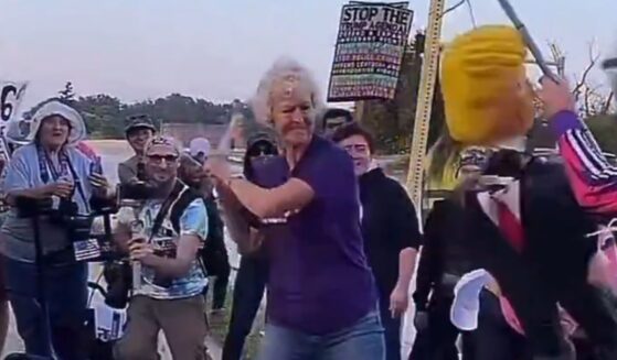 The woman's shirt bore a message about kindness and doing unto others as you would have them do unto you. Then someone put a stick in her hand and held out an effigy of President Donald Trump.