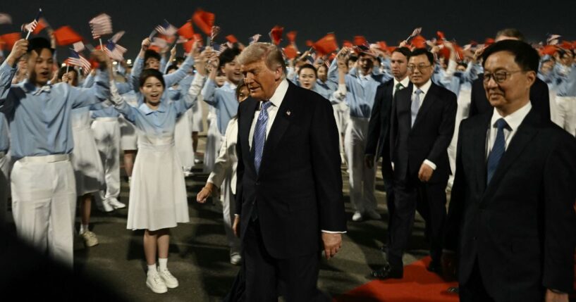 President Donald Trump is escorted by China's Vice President Han Zheng, right, upon his arrival at Beijing Capital Airport Wednesday.