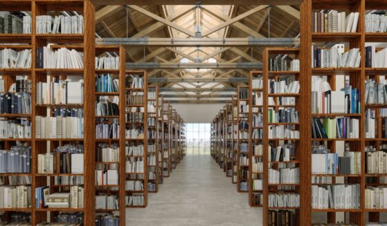 A library interior with books on wooden bookshelves.