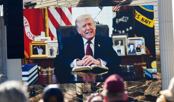 Attendees watch a pre-recorded video of President Donald Trump reading from the Bible during "Rededicate 250: A National Jubilee of Prayer, Praise, and Thanksgiving" on the National Mall in Washington, D.C., on May 17, 2026.