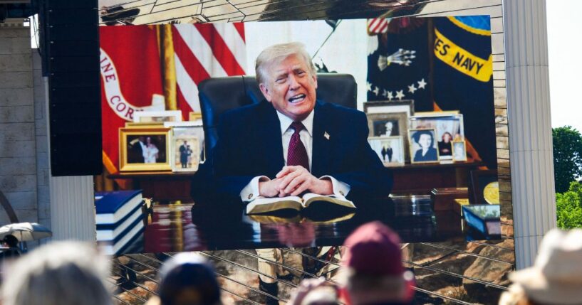 Attendees watch a pre-recorded video of President Donald Trump reading from the Bible during "Rededicate 250: A National Jubilee of Prayer, Praise, and Thanksgiving" on the National Mall in Washington, D.C., on May 17, 2026.