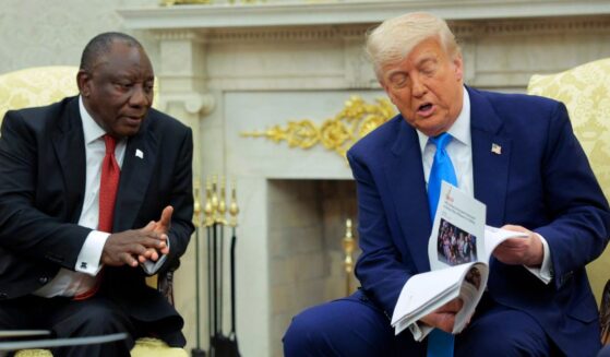 President of South Africa Cyril Ramaphosa looks on as President Donald Trump displays articles he says report violence against white South Africans in the Oval Office of the White House on May 21, 2025, in Washington, D.C.