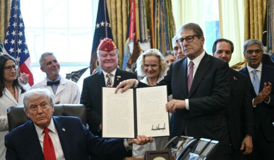 President Donald Trump and Howard Kessler, founder of the Commonwealth Project, hold up an executive order easing restrictions on marijuana in the Oval Office at the White House in Washington, D.C., on Dec. 18, 2025.