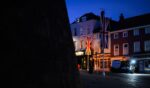 United Kingdom banners are illuminated by a headlight in the street outside Windsor Castle on Sept. 12, 2025, in Windsor, England.