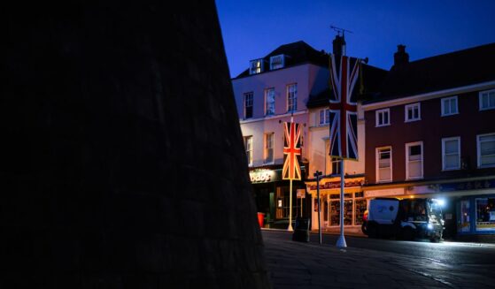 United Kingdom banners are illuminated by a headlight in the street outside Windsor Castle on Sept. 12, 2025, in Windsor, England.