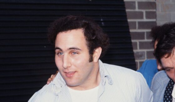 Police officers escort accused and ultimately convicted serial killer David Berkowitz, known as the Son of Sam, into the 84th precinct station in New York on Aug. 10, 1977.