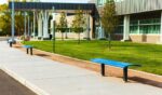 A high school with a bus stop and benches in the United States.