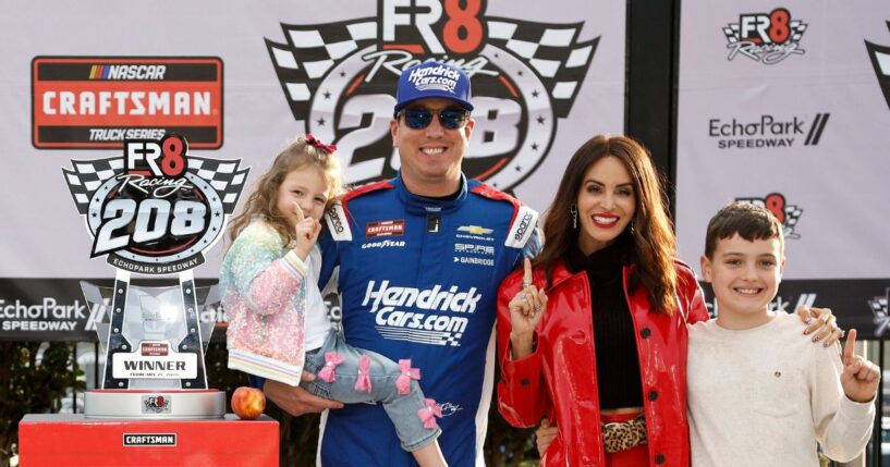 Kyle Busch celebrates with daughter, Lennix Busch, son, Brexton Busch, and wife, Samantha Busch in victory lane after winning the NASCAR Craftsman Truck Series Fr8 Racing 208 at Echo Park Speedway on Feb. 21, 2026, in Hampton, Georgia.