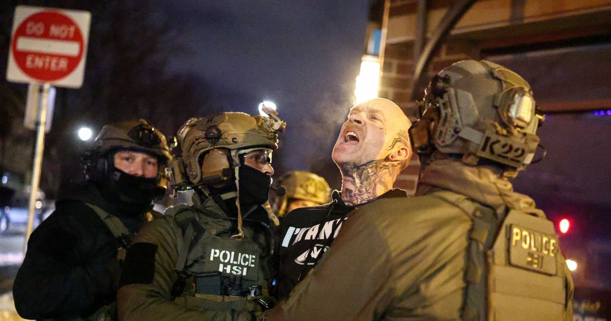 Federal agents with Homeland Security Investigations detain a protestor wearing an "Antifa" shirt outside a residential building in Minneapolis, Minnesota, on Feb. 5, 2026.