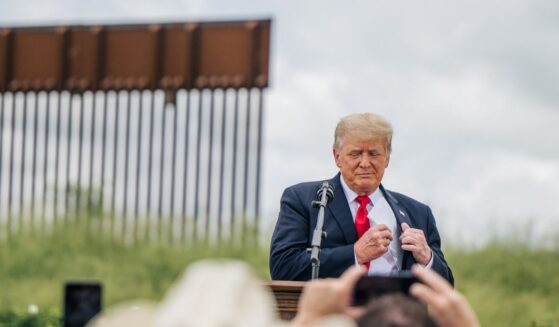 President Donald Trump pulls out his notes before speaking during a tour to an unfinished section of the border wall on June 30, 2021, in Pharr, Texas.