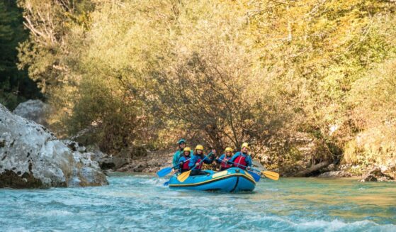 A young family with a mother guiding her three kids on a rafting expedition.