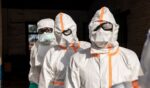 Workers line up to disinfect their protective equipment at General Referral Hospital of Mongbwalu during the Ebola outbreak response in Mongbwalu, Ituri province, eastern Democratic Republic of Congo, on May 20, 2026.