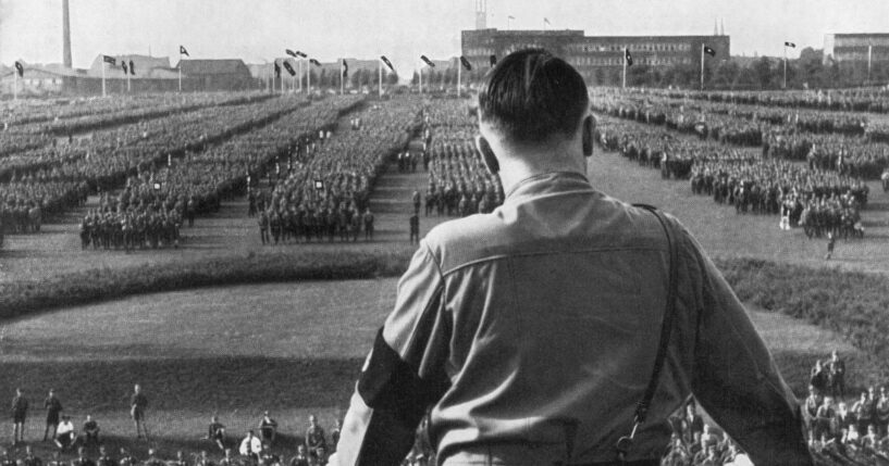 German Fuhrer and Nazi leader Adolf Hitler addresses soldiers with his back facing the camera at a Nazi rally in Dortmund, Germany.