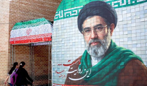 Women walk past a banner depicting Iran's current supreme leader Ayatollah Mojtaba Khamenei along a street Tehran on May 6, 2026.