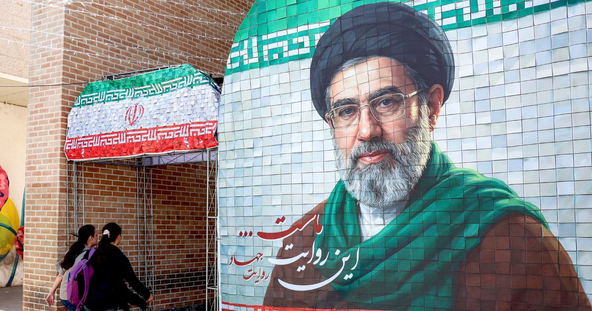 Women walk past a banner depicting Iran's current supreme leader Ayatollah Mojtaba Khamenei along a street Tehran on May 6, 2026.