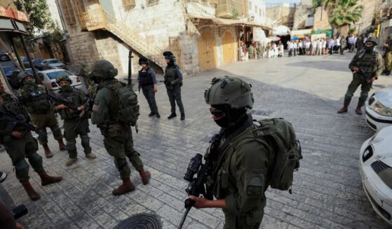 Israeli soldiers stand in the way of reporters recording with their cameras in the Old City of Hebron, in the West Bank, on May 9, 2026.