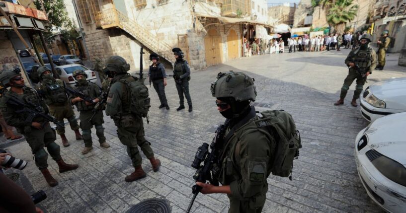 Israeli soldiers stand in the way of reporters recording with their cameras in the Old City of Hebron, in the West Bank, on May 9, 2026.