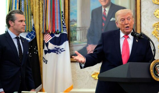 President Donald Trump takes questions as Secretary of War Pete Hegseth looks on during a ceremony for newly sworn in Secretary of the Department of Homeland Security Markwayne Mullin in the Oval Office at the White House on March 24, 2026, in Washington, D.C.