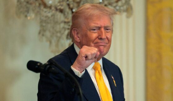 President Donald Trump grins and pumps his fist in a February file photo at a White House event for Black History Month.