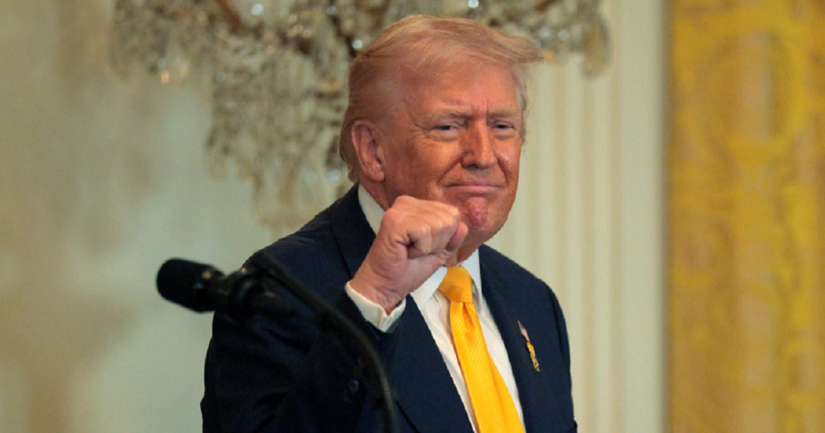 President Donald Trump grins and pumps his fist in a February file photo at a White House event for Black History Month.
