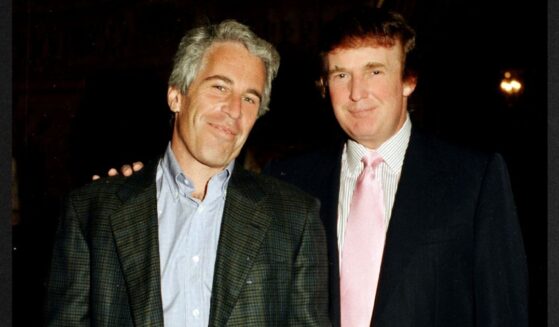 Then-financier Jeffrey Epstein, left, and then-real estate developer Donald Trump pose together at the Mar-a-Lago estate in Palm Beach, Florida, in a file photo dated Feb. 22, 1997. Their relationship soured not long after, and new evidence indicates Epstein was actively trying to find dirt on Trump when he died in prison in 2019.
