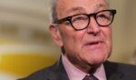 Senate Minority Leader Chuck Schumer stands in a hallway as he takes questions from the press on June 2, 2026.