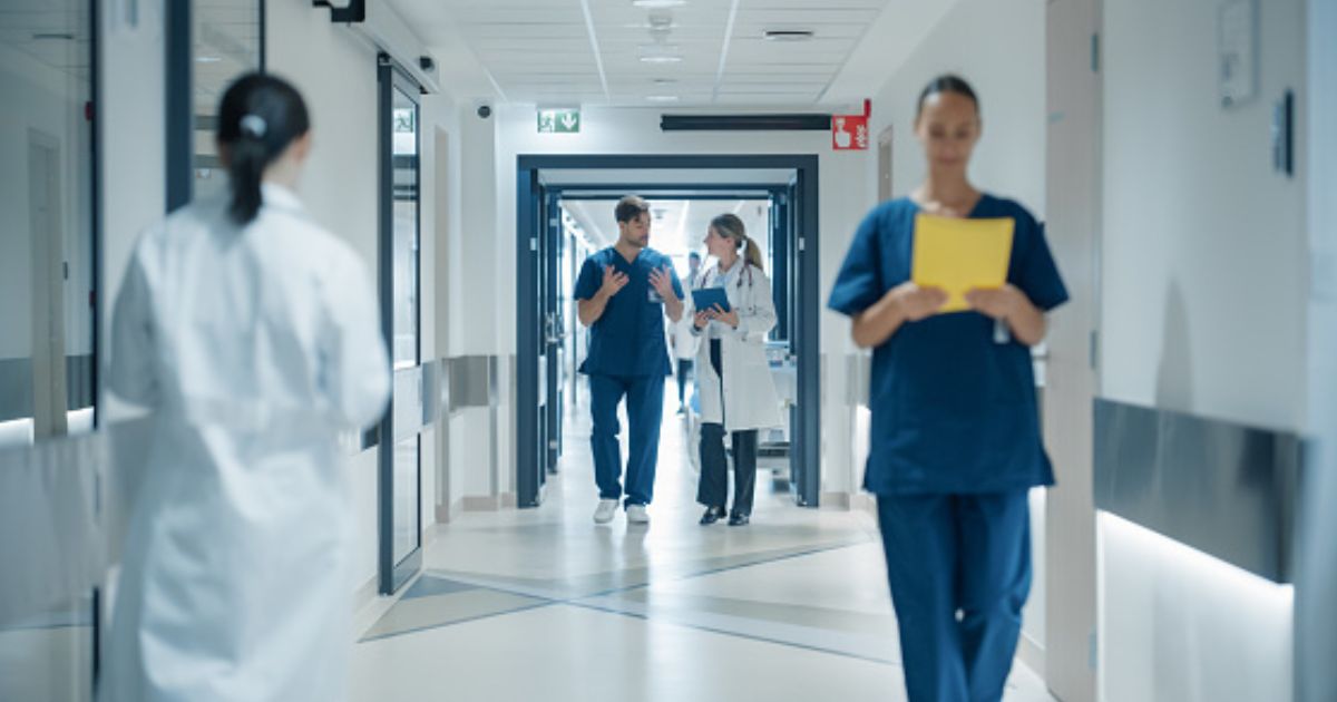 Doctors and nurses walk in a hospital hall.