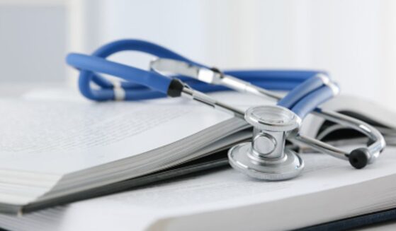A stethoscope sits on a stack of books.