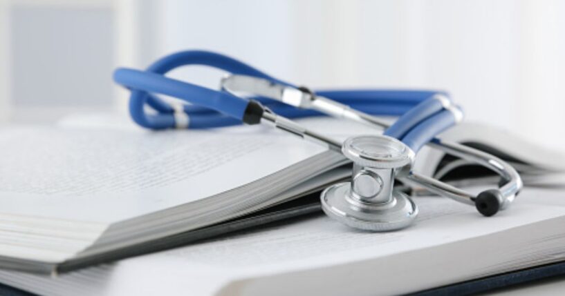 A stethoscope sits on a stack of books.