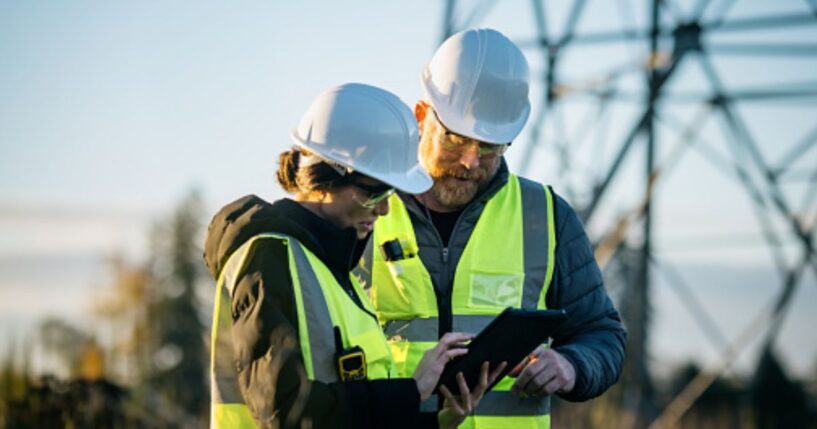 A man and a woman stand at a utility center as they stare at a tablet.