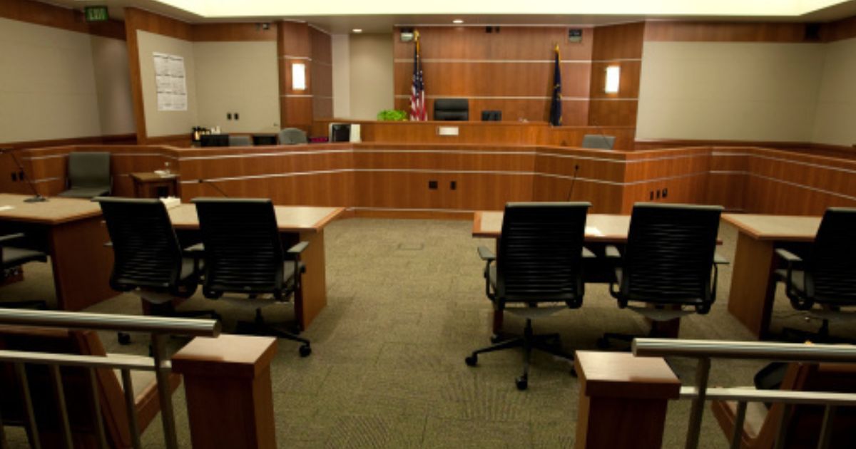 A modern courtroom sits empty under dim lights.