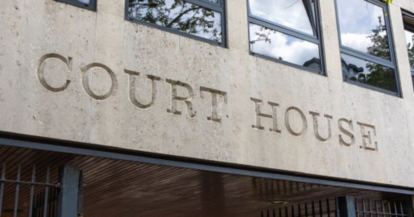 The lettering of a court house is shown on the concrete wall of a courthouse.