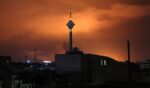 Milad (Birth) Tower, the tallest tower in Iran at 435 metres, is pictured before a lit up sky following airstrikes in Tehran on March 7.