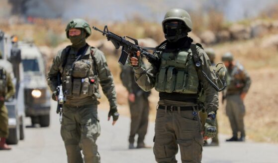 Israeli soldiers walk near a roadside fence in the occupied West Bank on June 5, 2026.