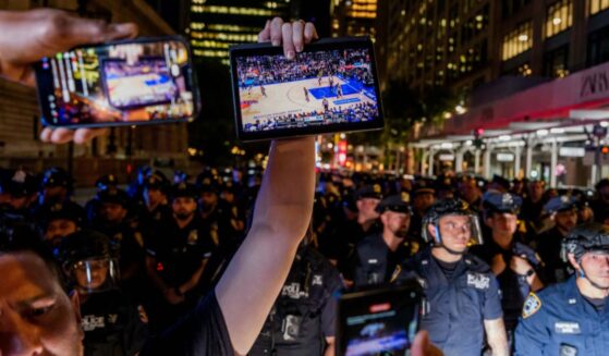 A Knicks fan holds up a screen of the NBA finals game between New York City and San Antonio at a watch party in Bryant Park for Game 3 of the Finals in New York City on June 8, 2026.