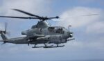 A U.S. Marine Corps AH-64 Apache helicopter flies through the sky on April 29, 2018.