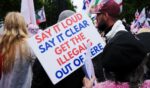 An anti-immigration sign is held by a protester at the Unite the Kingdom rally in London on May 16, 2026.