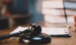 A gavel sits on top of a judge's desk.