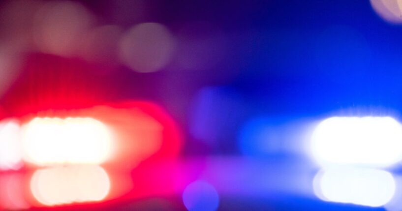 A police car with flashing lights at night.