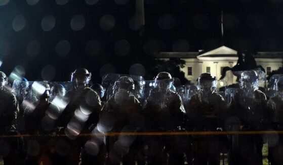 Police officers hold a perimeter behind the metal fence recently erected in front of the White House demonstrators gather to protest the killing of George Floyd on June 2, 2020, in Washington, D.C.