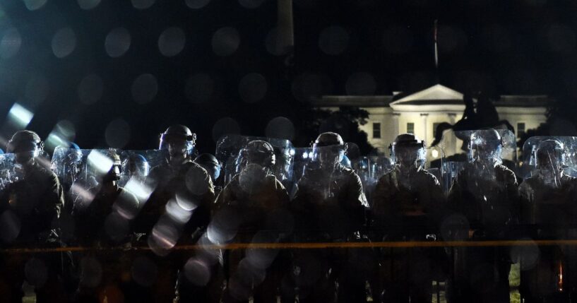 Police officers hold a perimeter behind the metal fence recently erected in front of the White House demonstrators gather to protest the killing of George Floyd on June 2, 2020, in Washington, D.C.