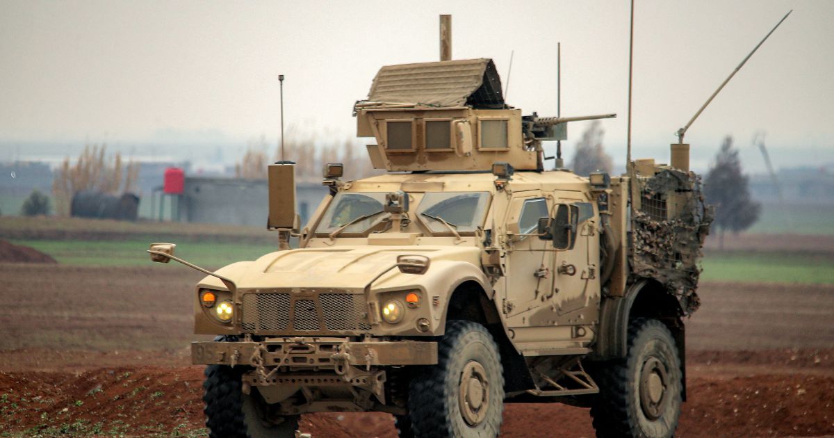A U.S. military mine-resistant ambush protected vehicle moves along a road in a convoy transporting Islamic State group detainees being transferred to Iraq from Syria, on the outskirts of Qahtaniyah in Syria's northeastern Hasakah province on Feb. 7, 2026.
