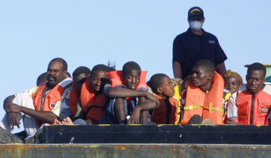 U.S. Coast Guard personnel watch over the 188 Haitians picked up Dec. 3, 2001, after their overloaded boat ran aground in 3 feet of water off the South Florida coast about 10 miles south of Miami.