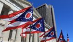 State of Ohio flags waving in front of the State House in Columbus, Ohio.