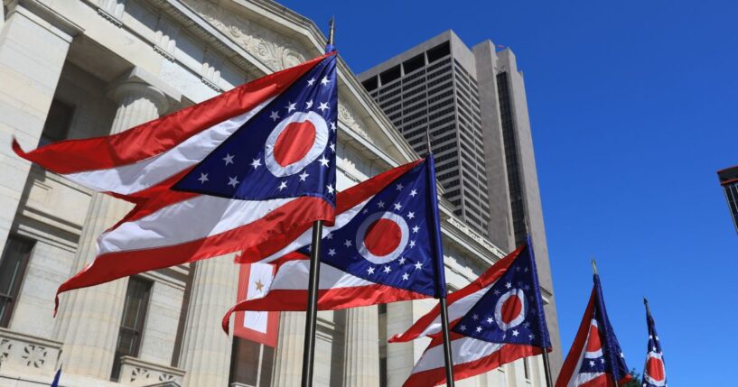 State of Ohio flags waving in front of the State House in Columbus, Ohio.