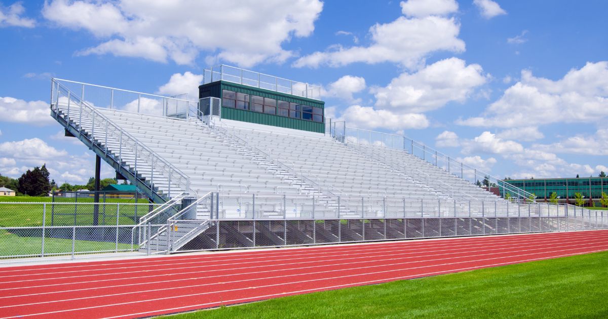 Bleachers at a high school football field with track.