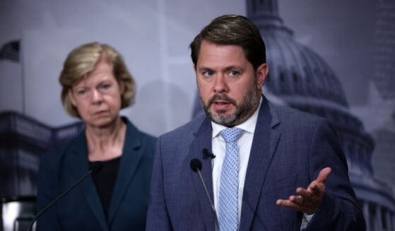 Sen. Tammy Baldwin listens as Sen. Ruben Gallego speaks during a news conference to introduce the Protect our Polls Act at the U.S. Capitol on June 18, 2026, in Washington, D.C.