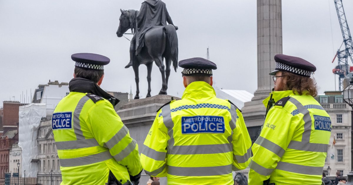 A group of three police officers in Trafalgar Square, Central London, on a chilly, grey day.